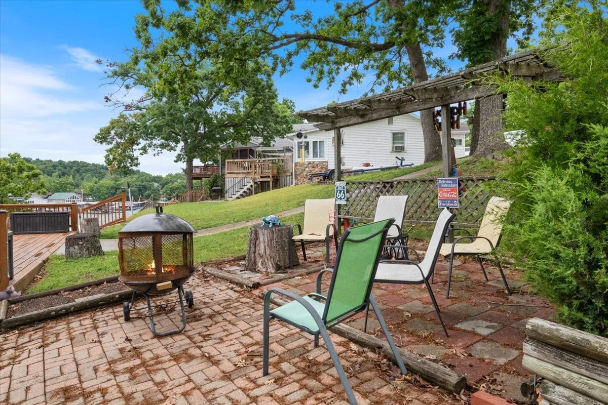 A cozy outdoor area featuring a fire pit surrounded by inviting seating, set against a scenic landscape view. The arrangement provides a warm, communal spot for evening gatherings under the stars.